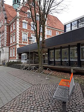 Foto der orangen Bank mit dem Rathaus Wanne im Hintergrund