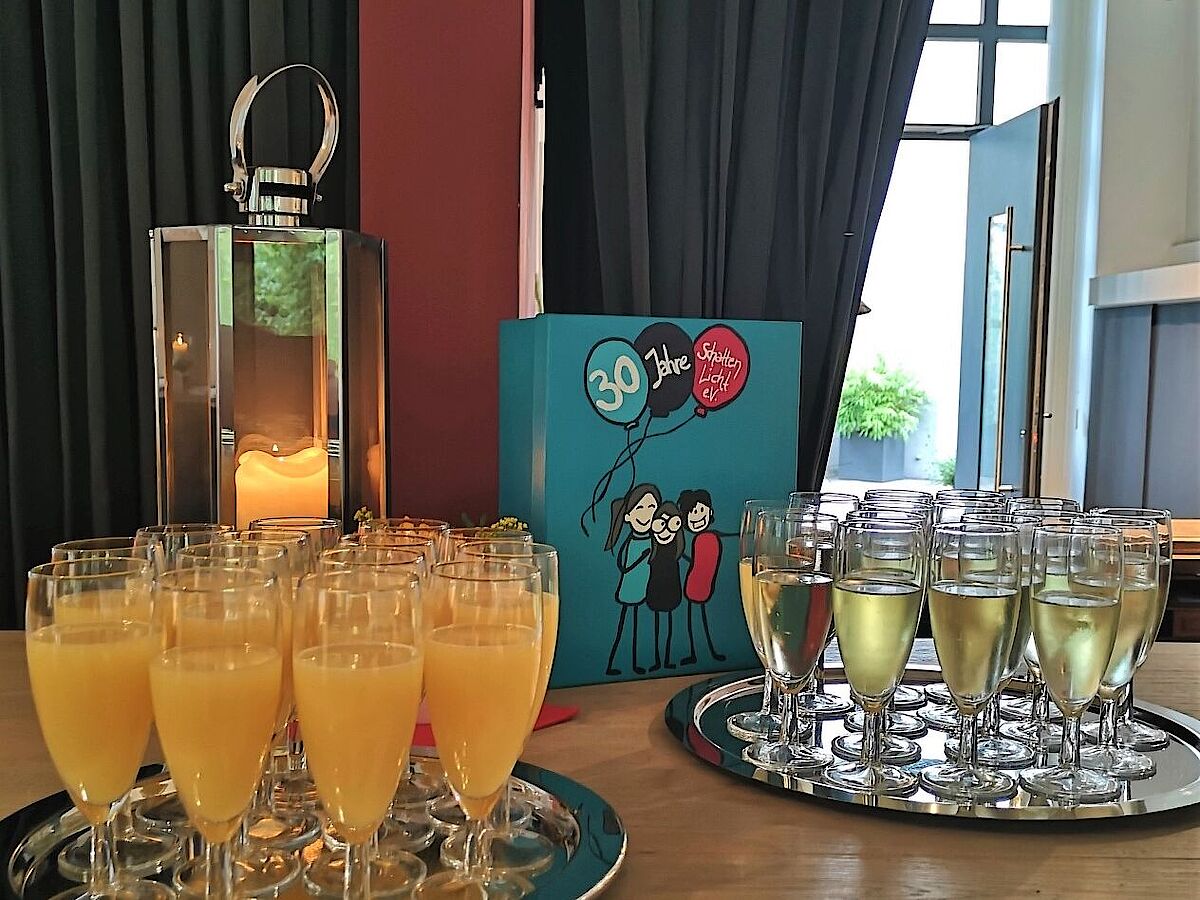 Foto Eingangsbereich Alte Druckerei mit Tisch, auf dem gefüllte Sektgläser für die Jubiläumsmatinee stehen