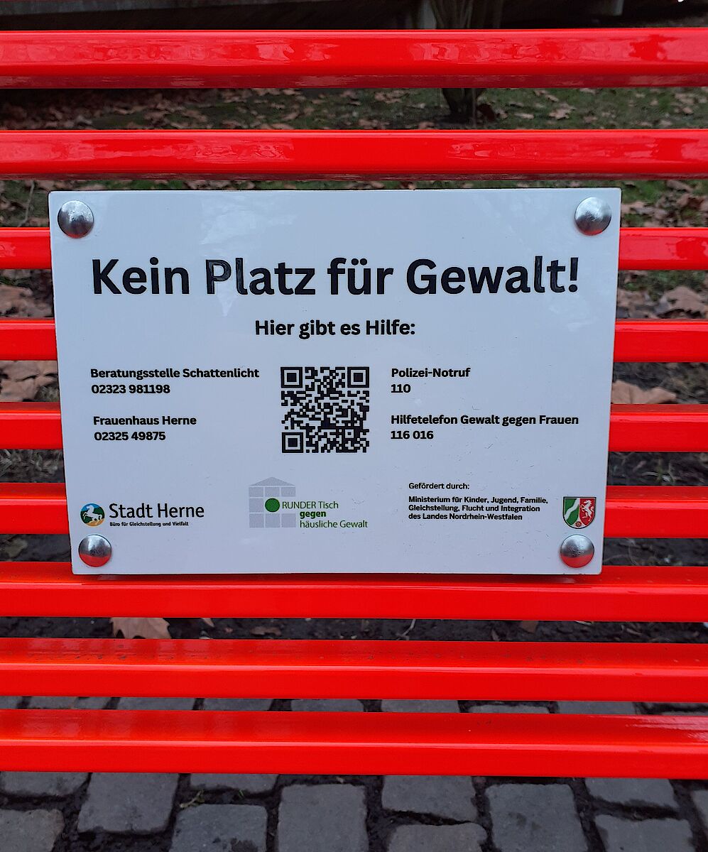 Detailaufnahme des Schiles mit Hilfsangeboten in Herne, das an der orangen Bank angebracht ist
